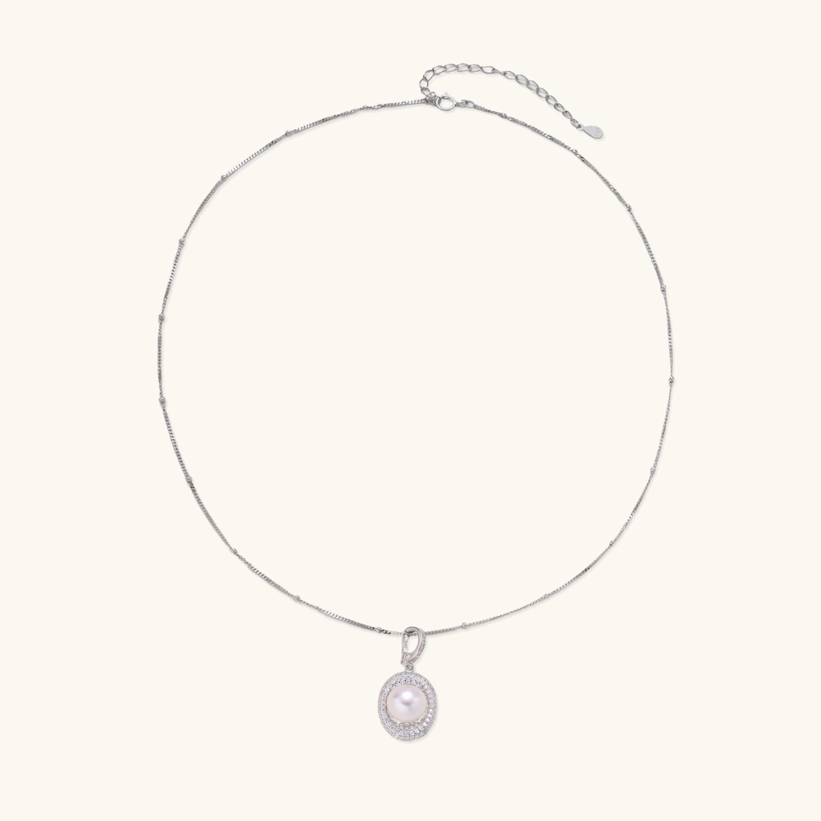Oval sterling silver pendant with crystal halo surrounding a white freshwater pearl on delicate chain