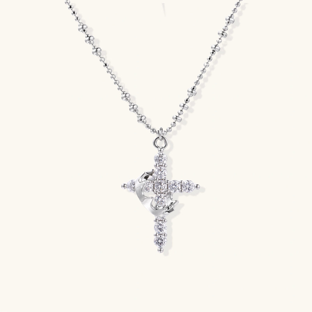 White gold-plated cross pendant adorned with sparkling zirconia stones and crescent moon accent on ball chain