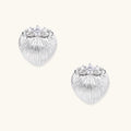 White gold-plated shell-textured stud earrings with three zirconia crystals on ridged surface against cream background.