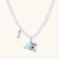 Pearl necklace with playful blue dog pendant accented with sparkly crystals on cream background.