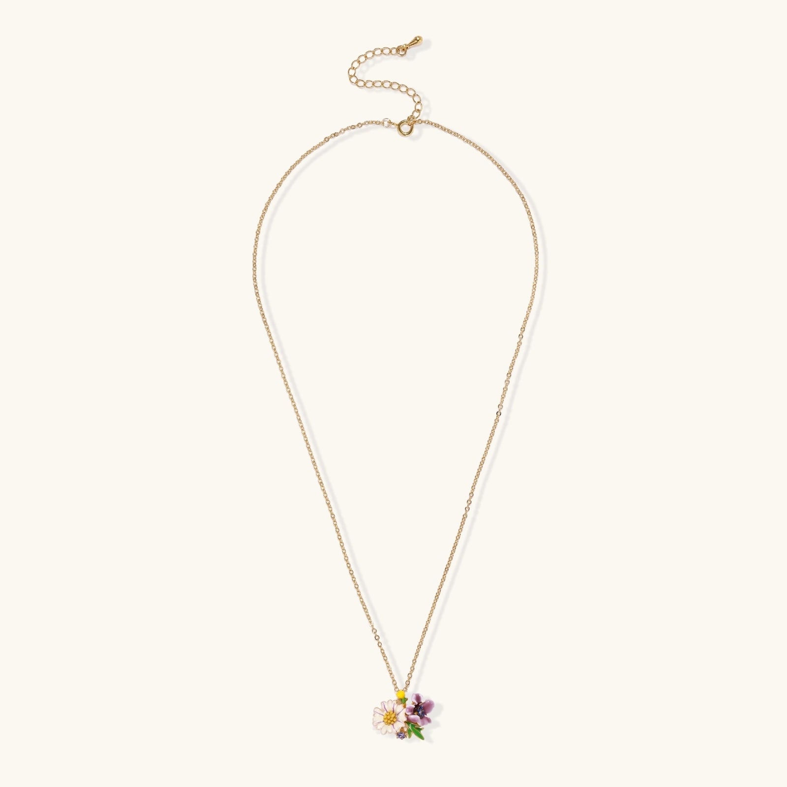 Gold-plated necklace with pink and purple enamel flower pendant featuring crystal accents on cream background