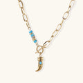 Gold chunky chain necklace with turquoise beaded accent and horn pendant on white background