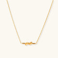 Dainty 18K gold plated necklace with infinity knot pendant on delicate chain against white background