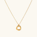 Delicate gold-plated necklace with three interlocking circle rings forming a minimalist knot pendant on cream background